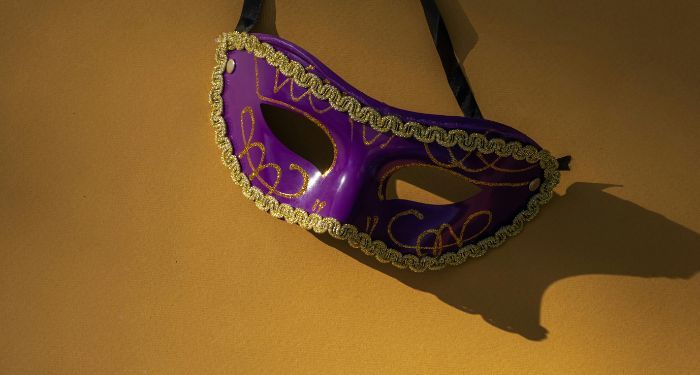 purple and gold mask against a gold backgorund.jpg.optimal