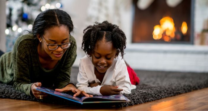 child reading book with parent christmas.jpg.optimal